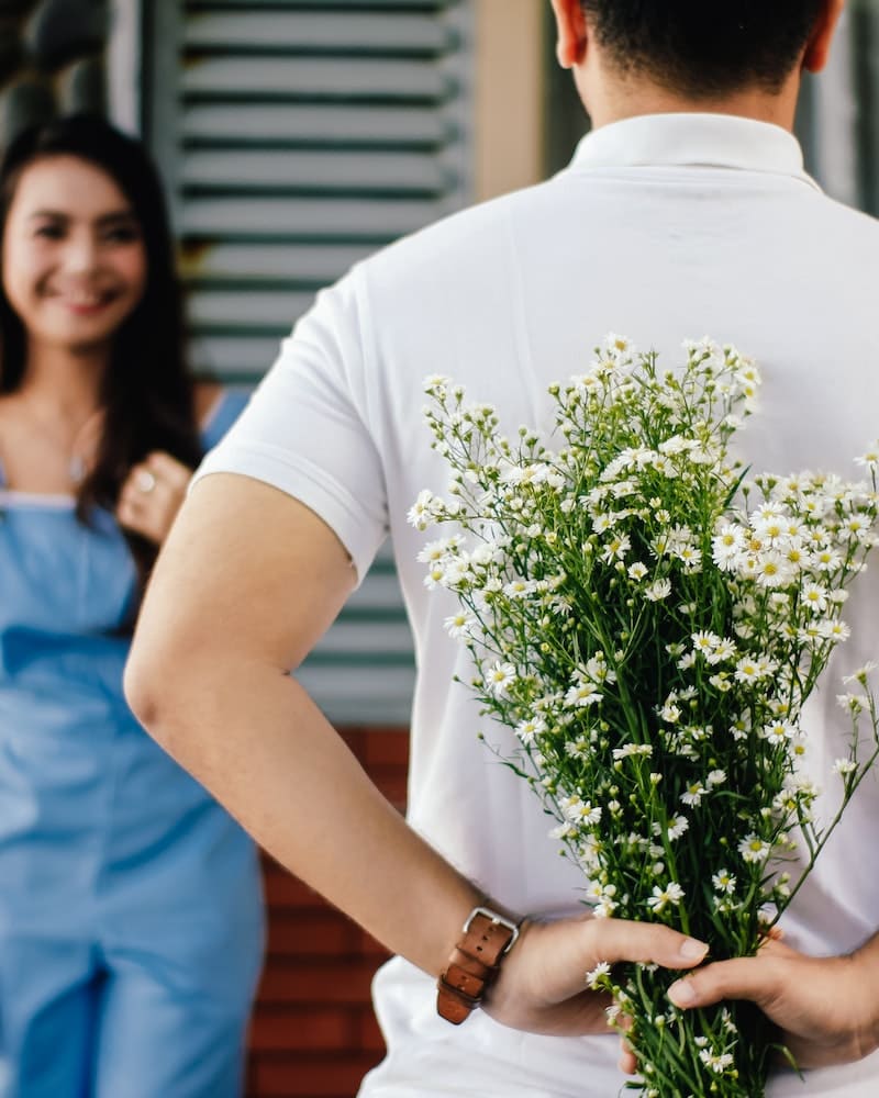 homem com ramo de flores escondido nas costas