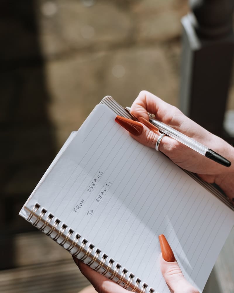 mulher com caderno ma mao