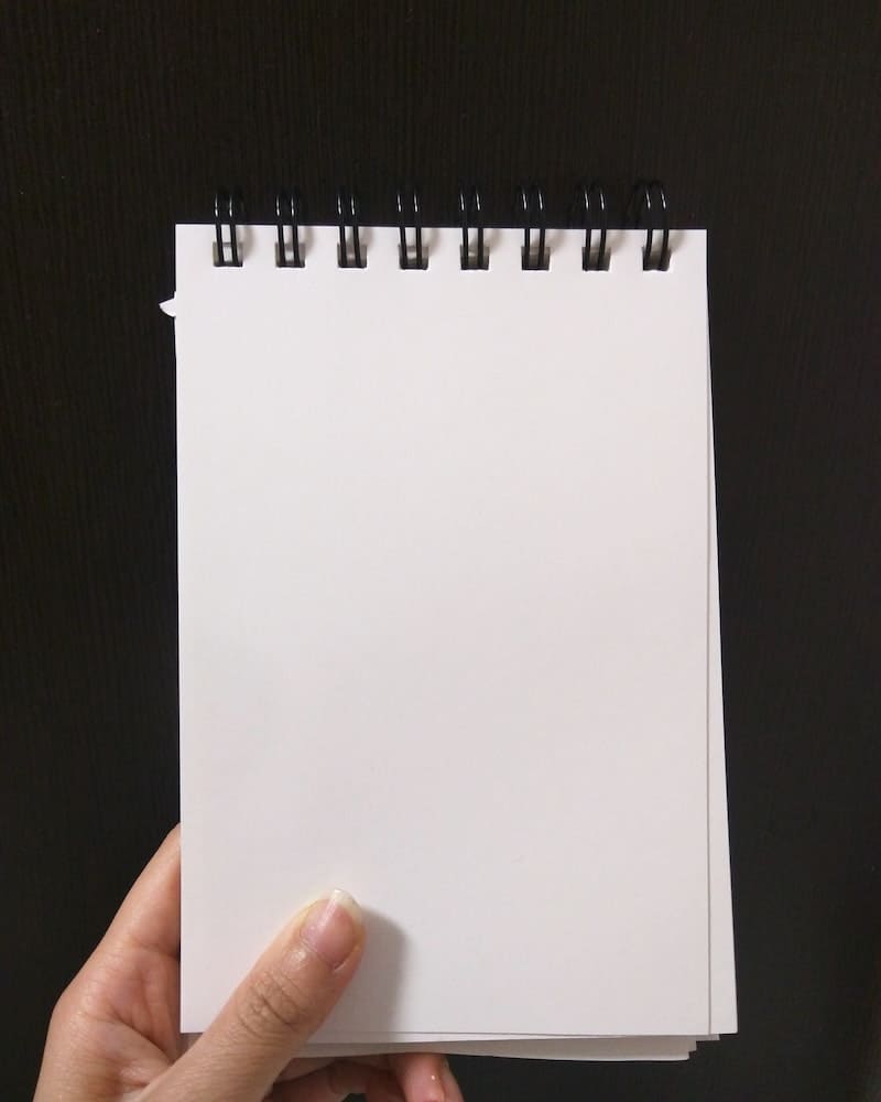 mulher pegando um caderno para fazer um ritual magico