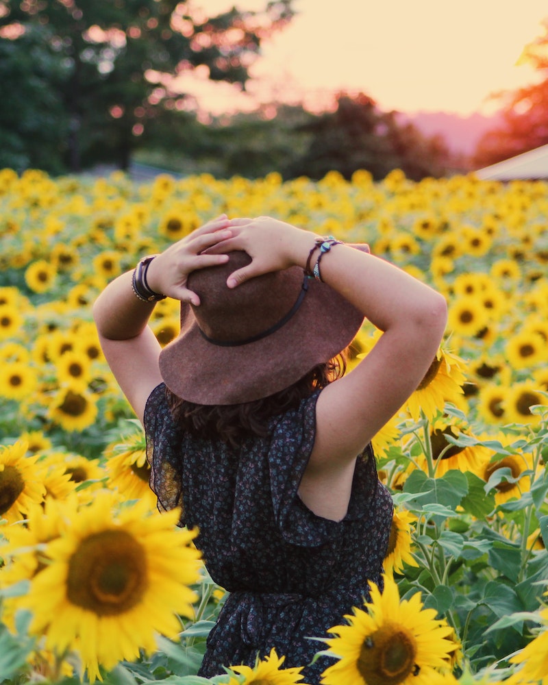 mulher dentro de um campo de girassol